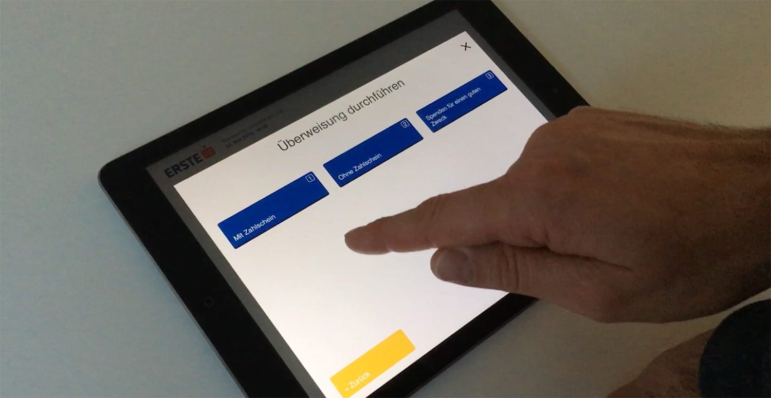 Ein iPad mit einfachem Klickdummy-Screen: Headline "Überweisung durchführen" mit 3 Buttons
