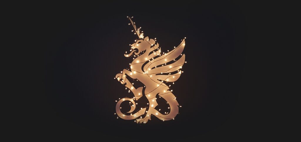 Logo der dmcgroup, weihnachtlich beleuchtet durch eine Lichterkette, auf dunklem Grund