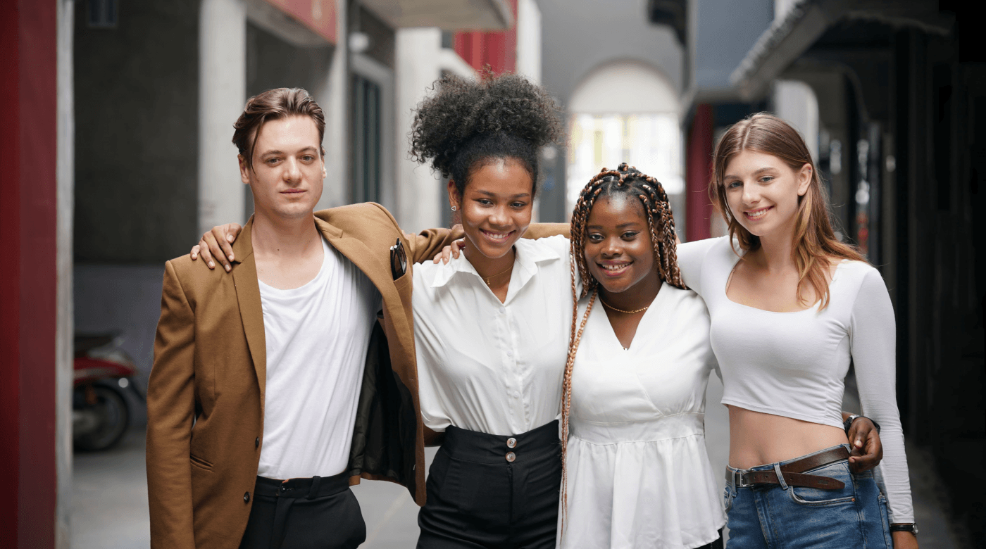 Vier junge Erwachsene stehen in einer Gasse und repräsentieren die Bedeutung der Mitarbeiterbindung für die Gen Z.