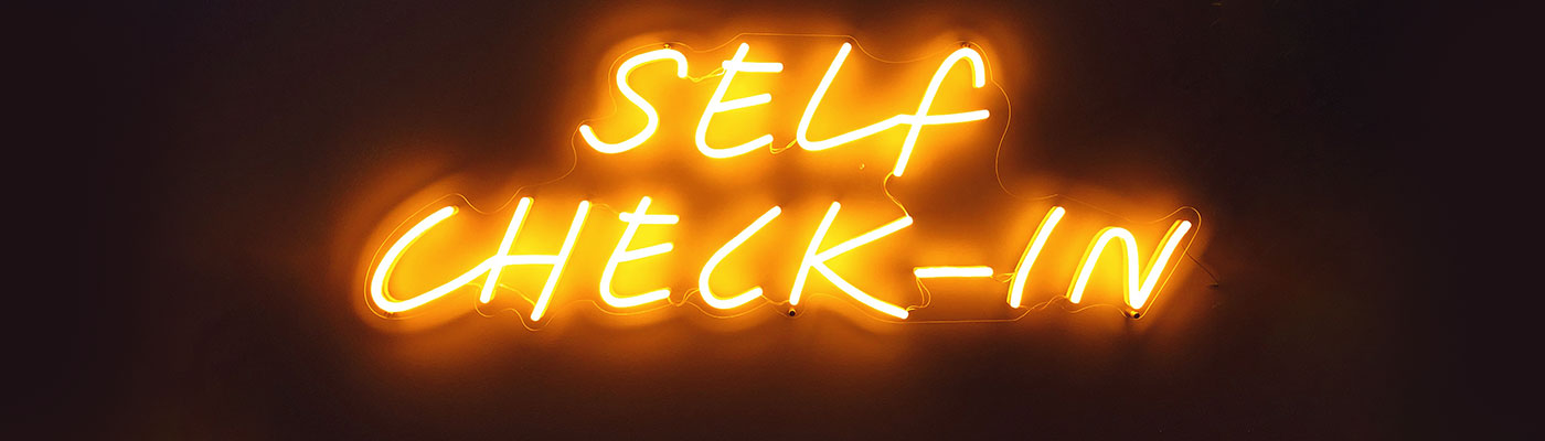 Neon-Schriftzug "Self Check-In" - ein Selfservice-Terminal macht's möglich